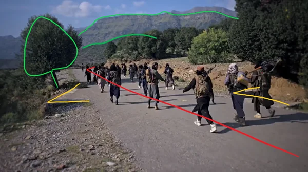A still from timestamp 6:55 shows the militants walking along a road