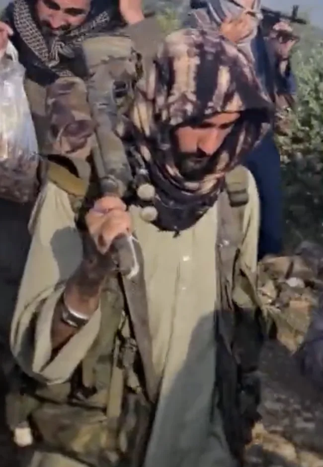 Frame at 05:20: Bolt-action rifle carried upright