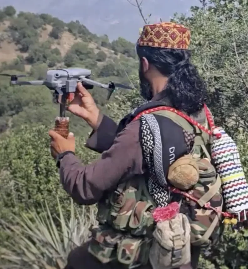 Frame at 00:33: Fighter holding a folding quadcopter