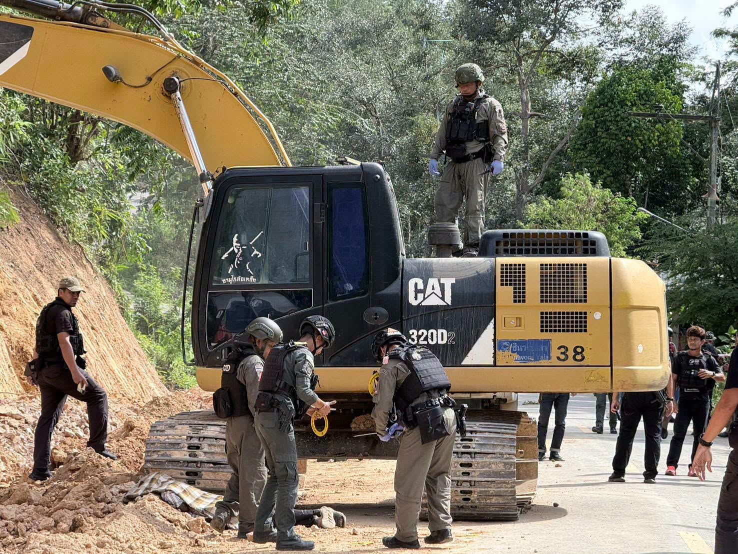 Roadside scene after the shooting, with police tape and officers examining the ground.