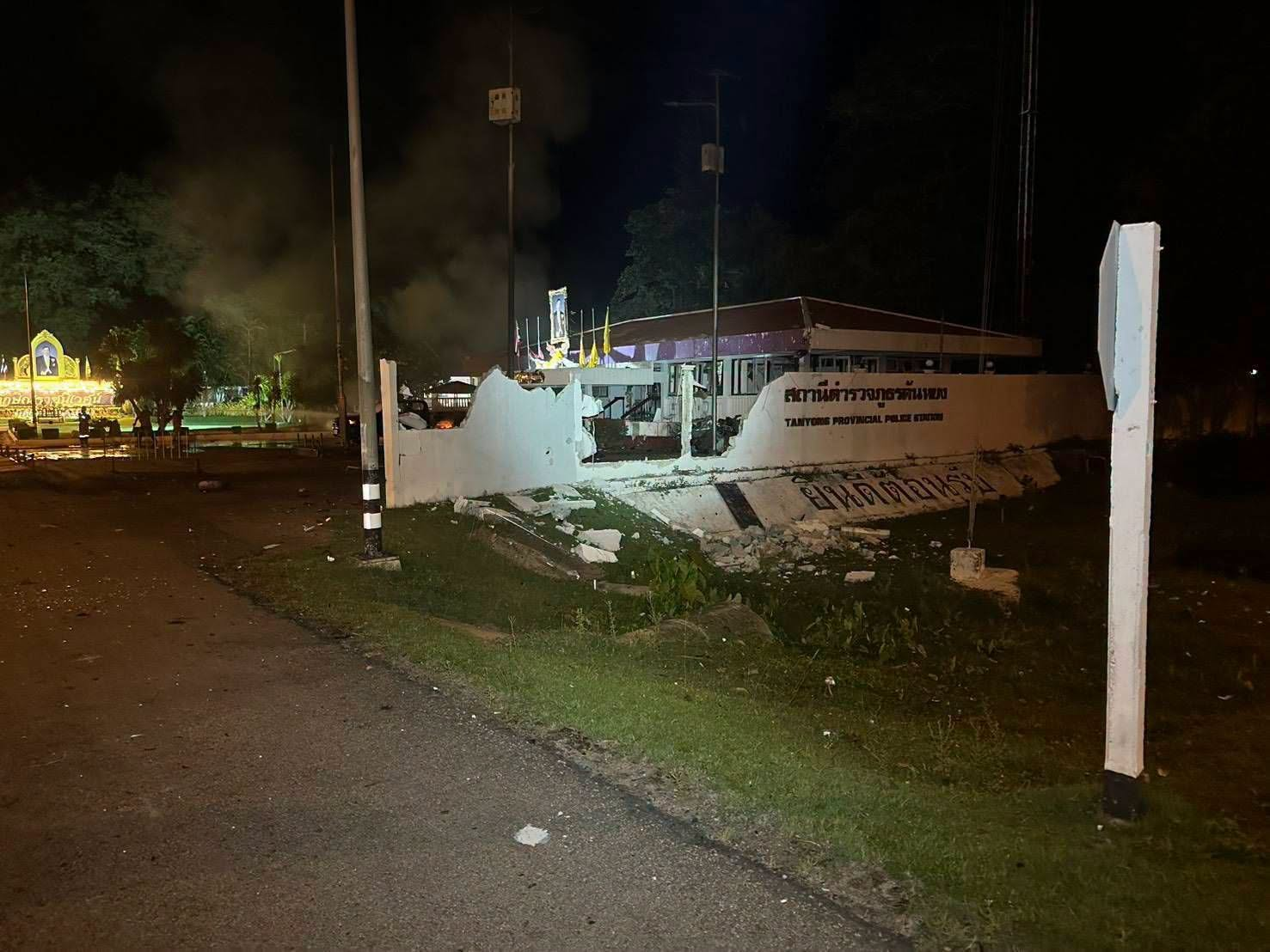 Photograph of the damaged vehicle and police station building after the car bomb explosion.